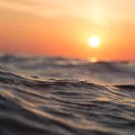 Aaltoileva meri ja laskeva aurinko